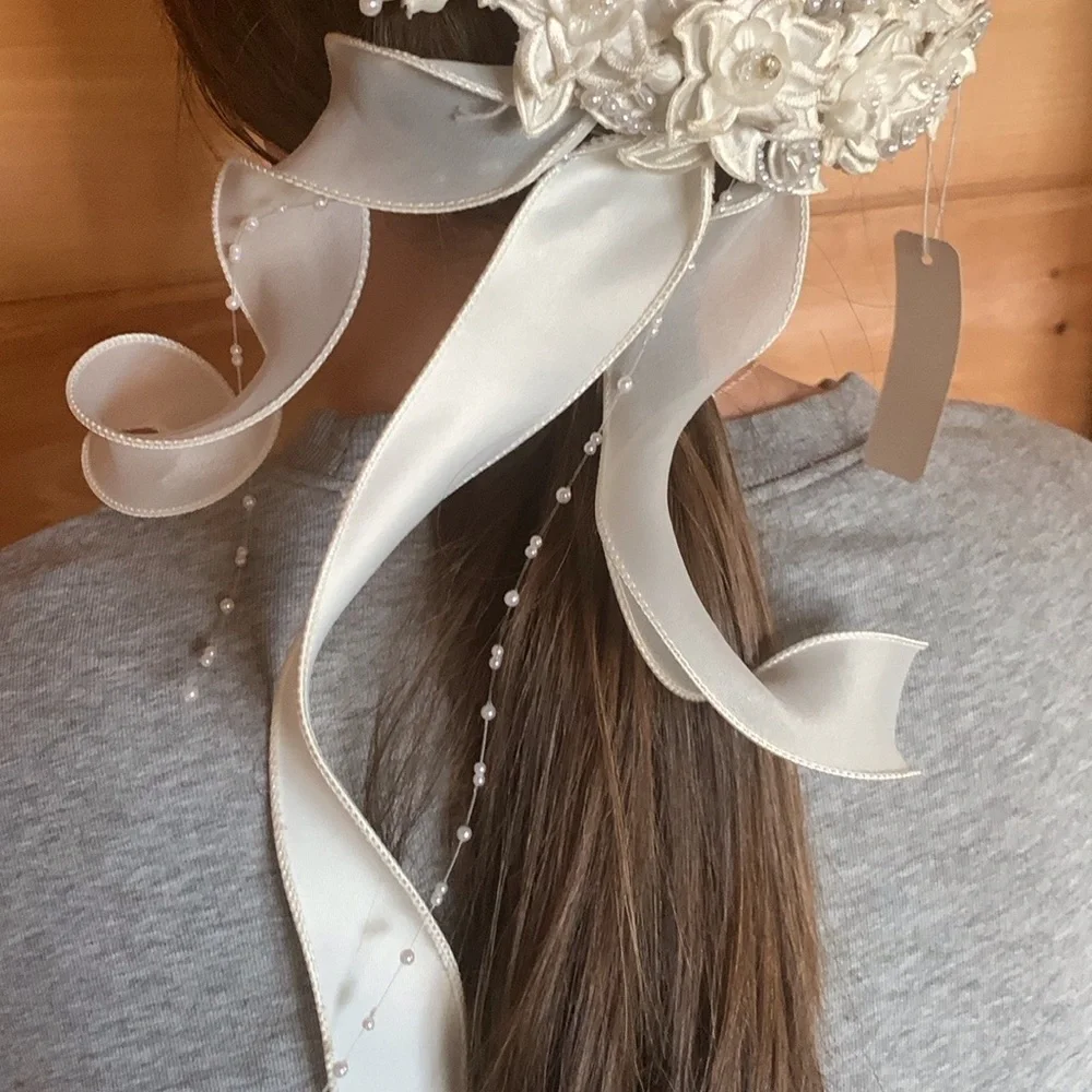 White floral and satin ribbon hairpiece with pearl and rhinestone detail